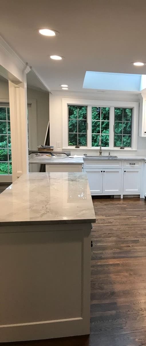 Kitchen after final construction cleaning — polished marble counters and spotless cabinetry