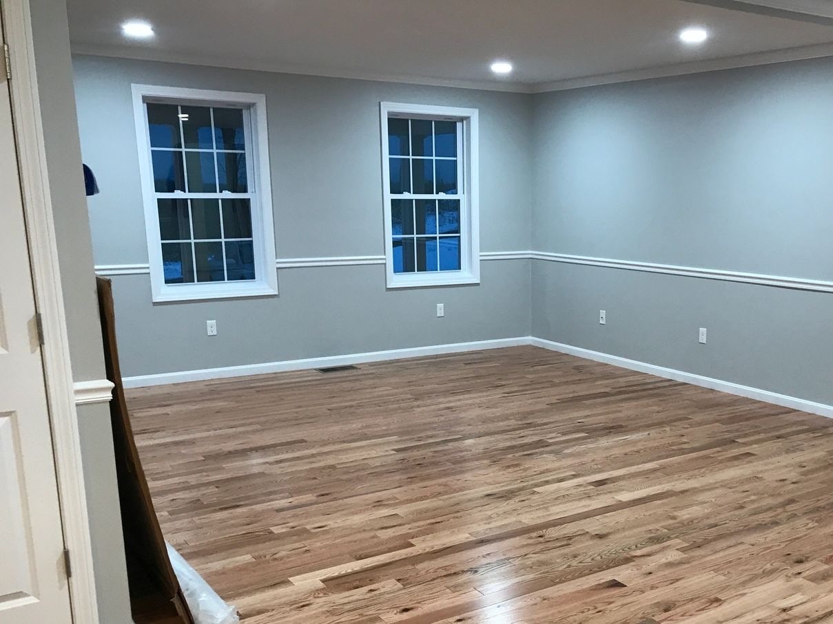 Empty room after new construction cleaning — clean hardwood floors, dust-free trim and windows