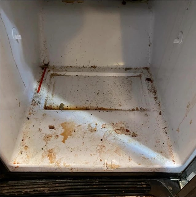Refrigerator shelf before cleaning — dried spills and staining across the surface and into the seams