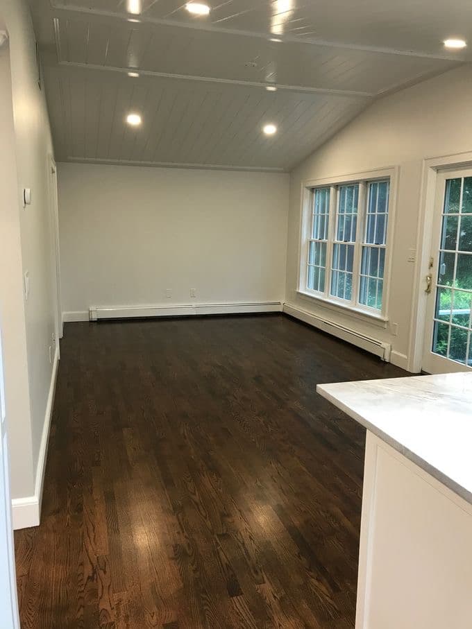 A great room with polished hardwood floors after post-construction cleaning