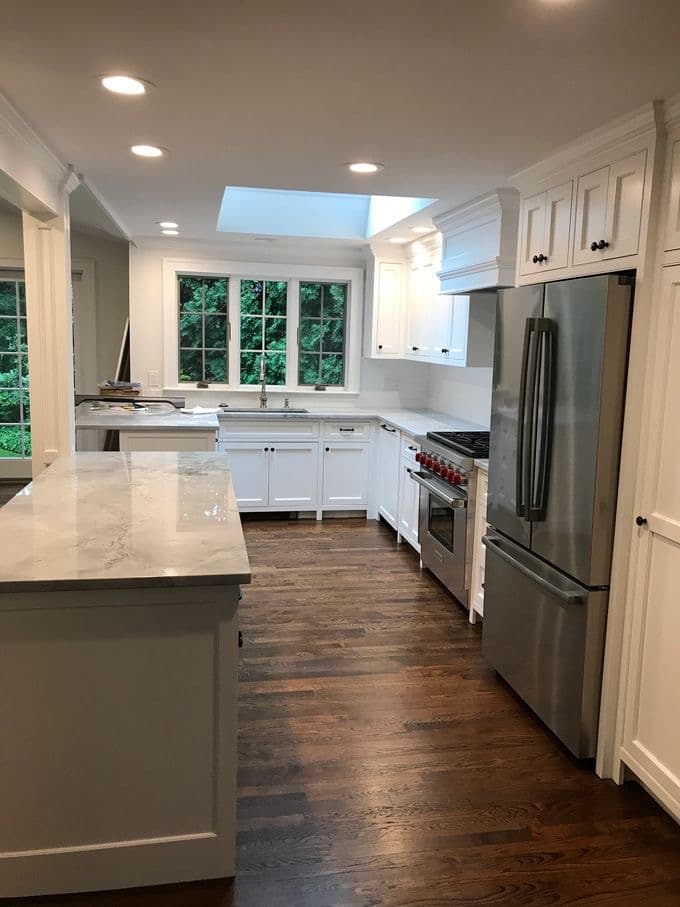 The same kitchen after post-construction cleaning — polished marble counters, spotless appliances and dust-free cabinetry