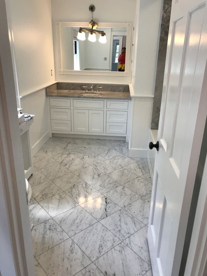 A spotless bathroom with polished marble floor after a residential cleaning