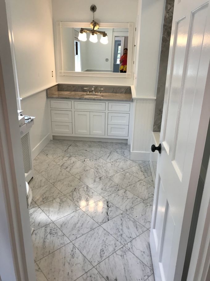 The same bathroom after final construction cleaning — marble floor and vanity polished