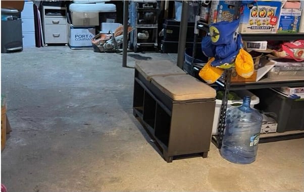 The same basement area after cleaning — floor clear and swept, remaining items stacked on the shelving