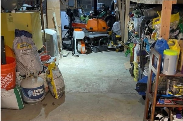 The same basement after cleaning — concrete floor clear and equipment stored along the walls