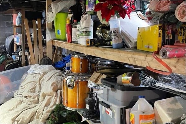 Cluttered basement shelving and floor before cleaning — tools, equipment and stored items piled together